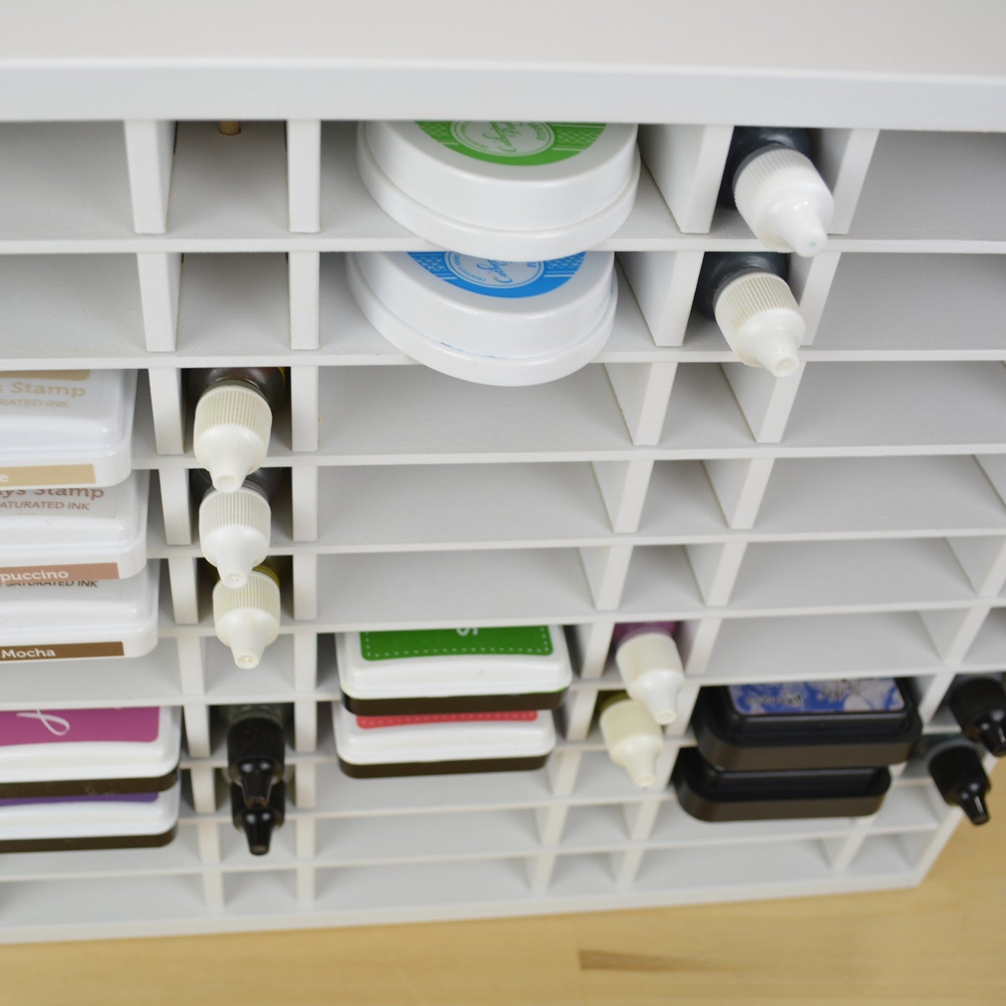Downward view of ink pads and refill bottles in a white organizer from OrganizeMore.