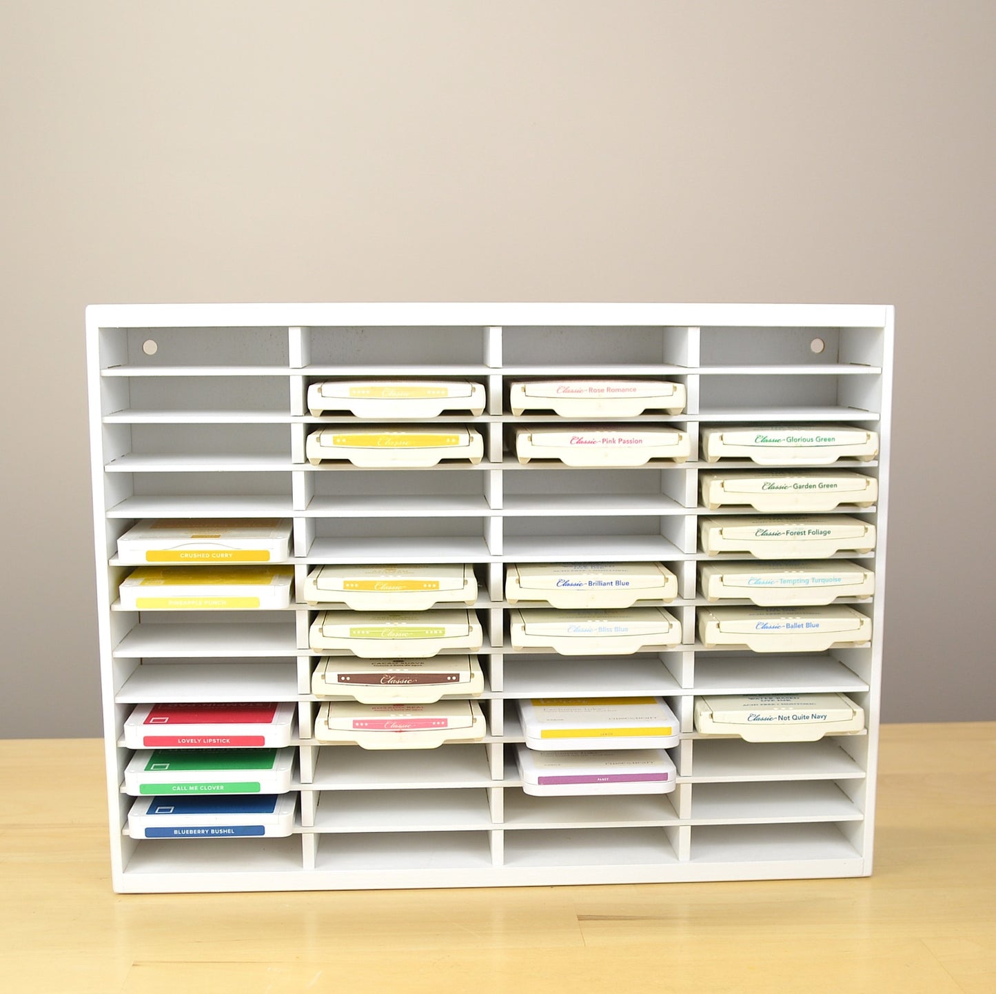 Front view of an ink pad organizer that's painted white and full of Stampin Up ink pads.