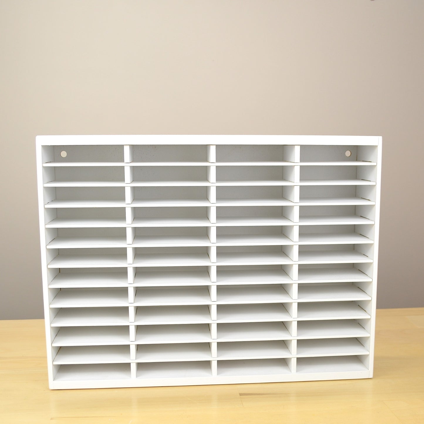 Front view of an empty ink pad holder that has 48 slots and hand painted white.