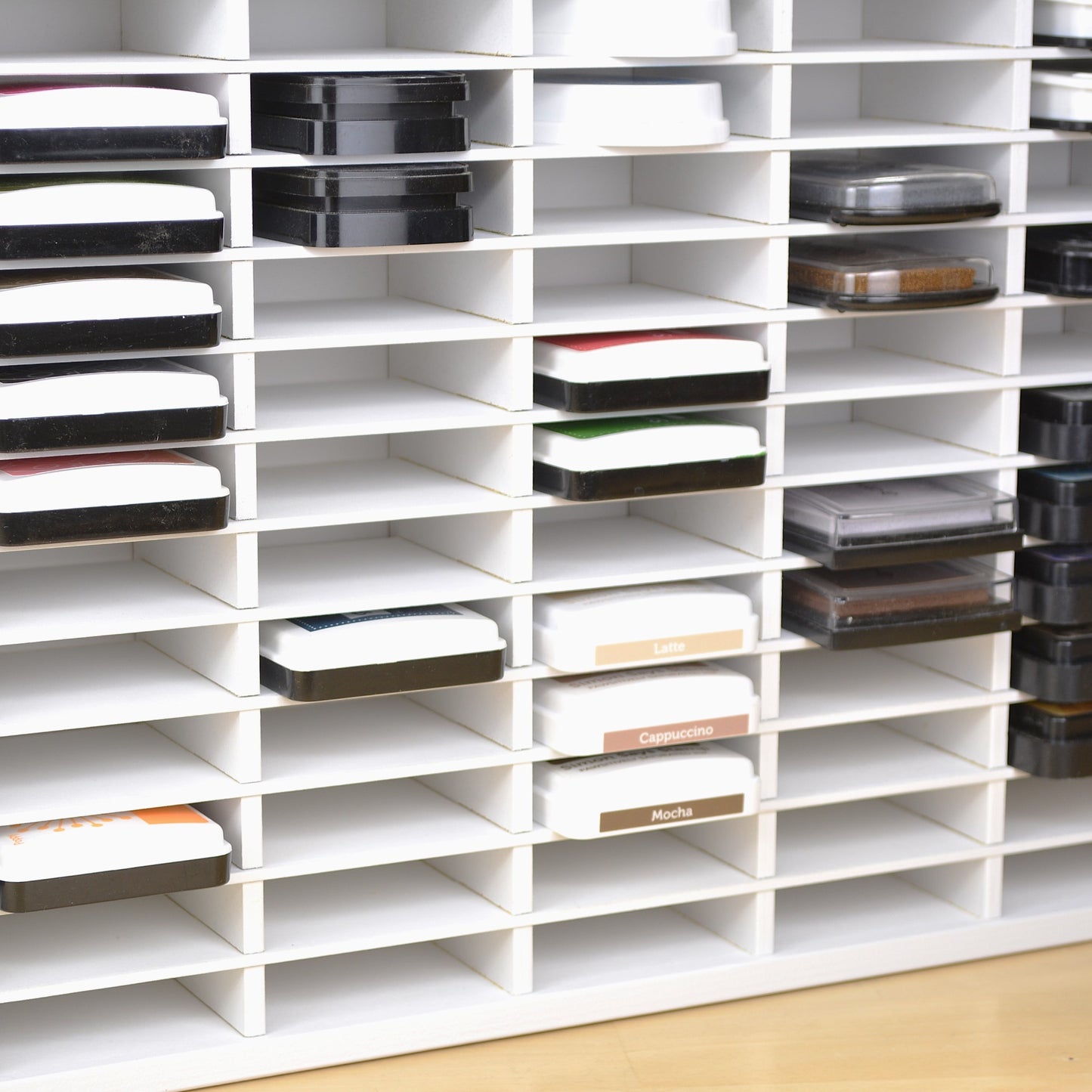 Closeup view of ink pads in a white craft organizer that has 72 slots.