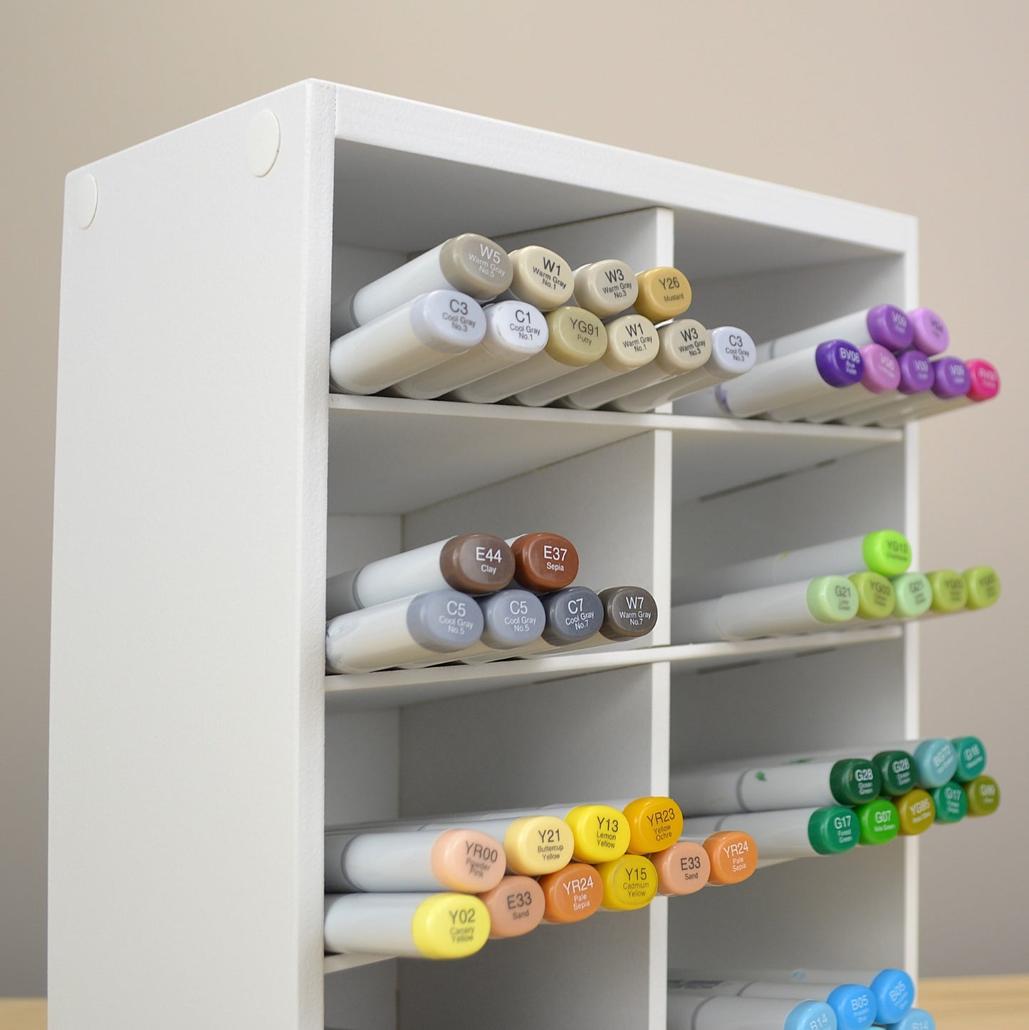 Side view of a white marker organizer with slanted shelves.