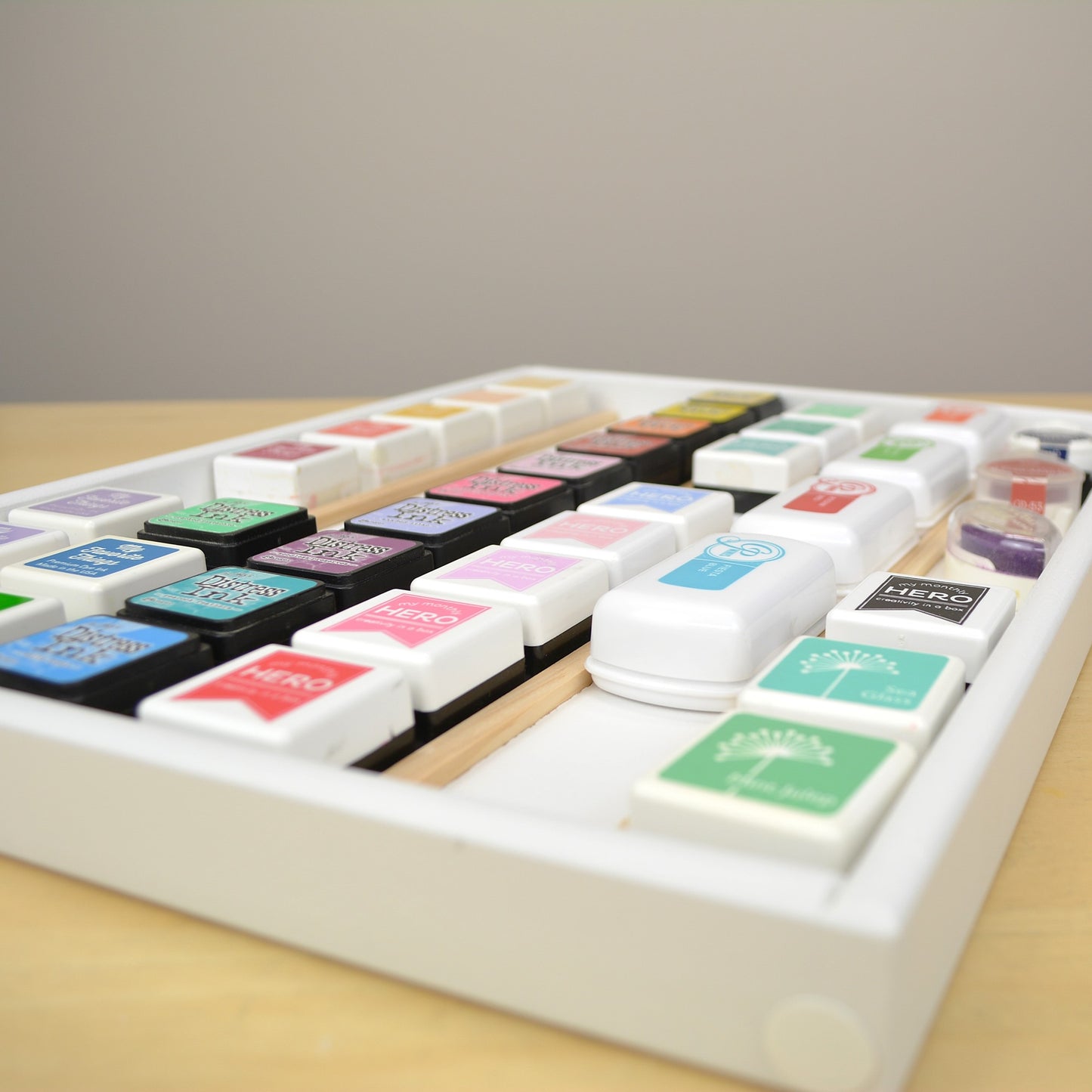 Side view of mini ink cubes in a divided wooden tray.