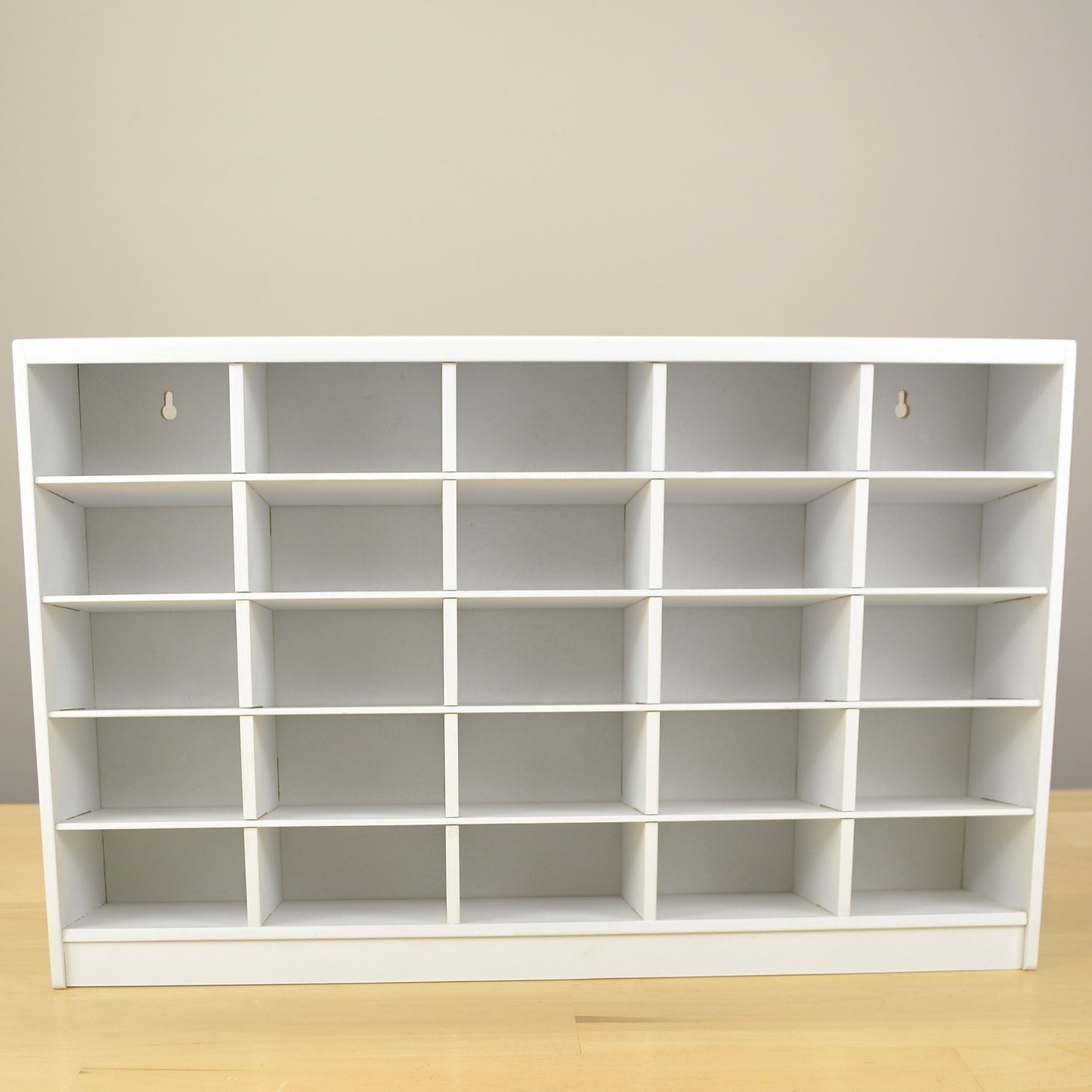 Front view showing the 25 cubbies of a white marker storage organizer.