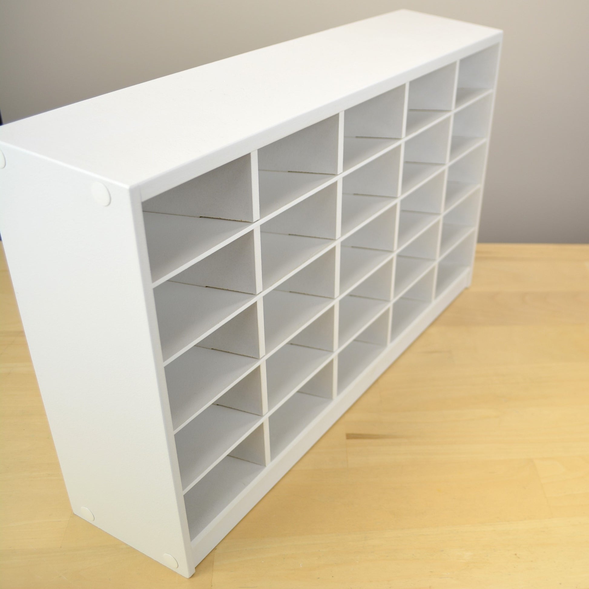 Side view of a white marker holder with slanted shelves.