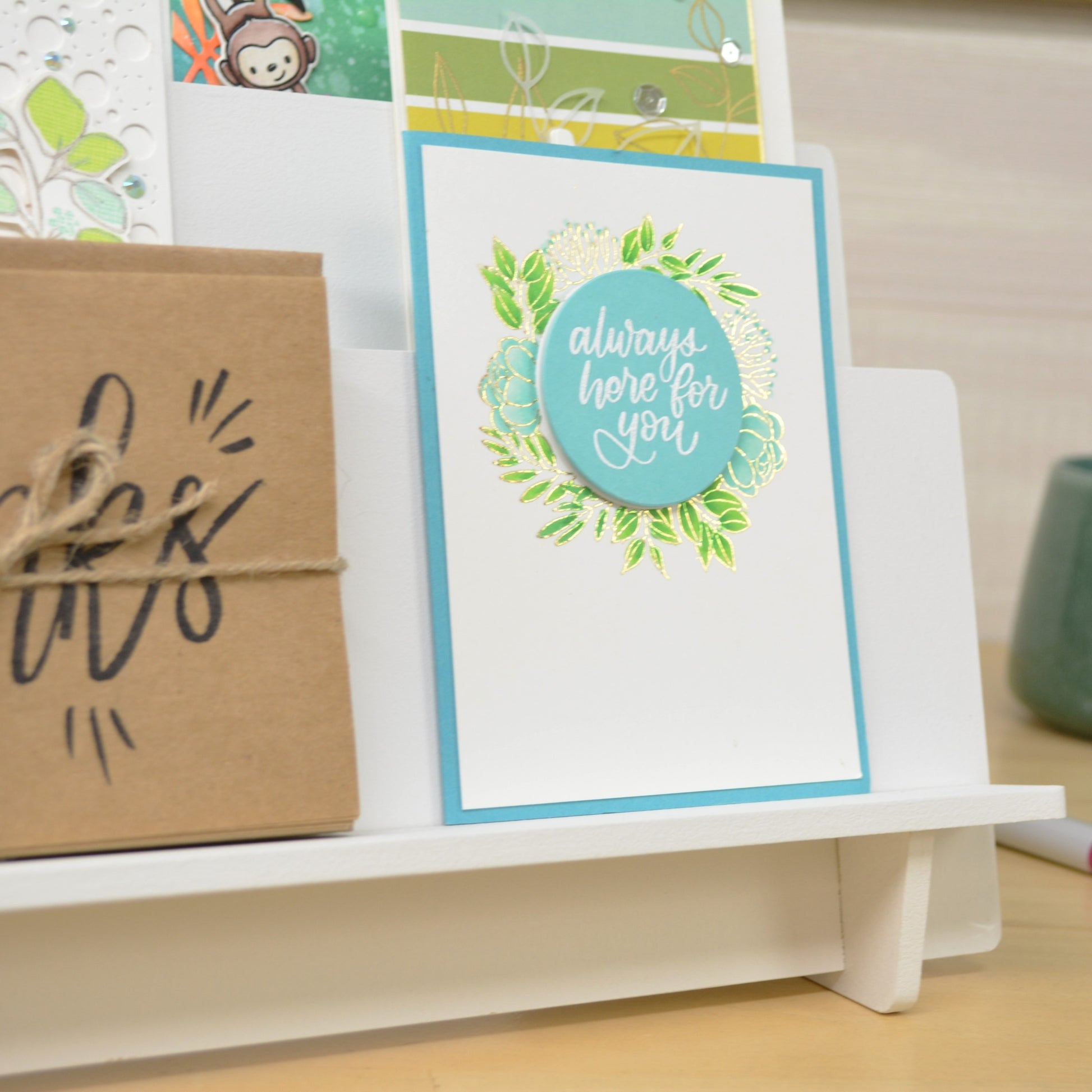 closeup of a greeting card displayed on a tiered shelf unit in a craft room
