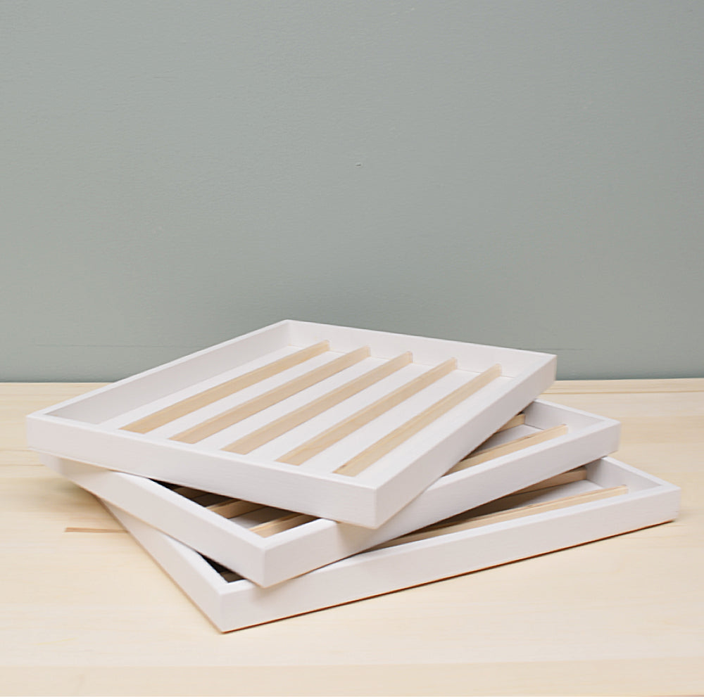 three white mini ink trays stacked together on a wooden surface