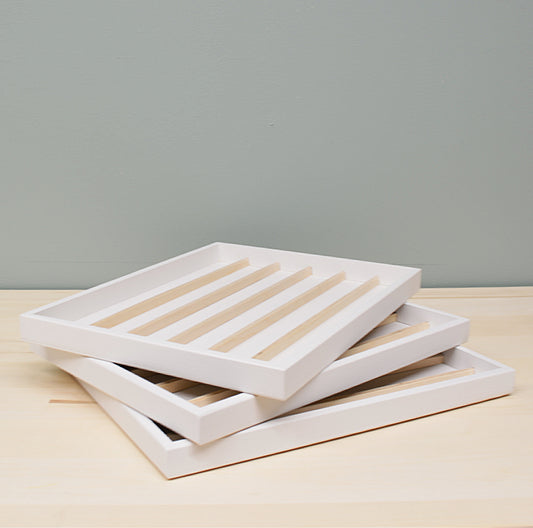 three white mini ink trays stacked together on a wooden surface