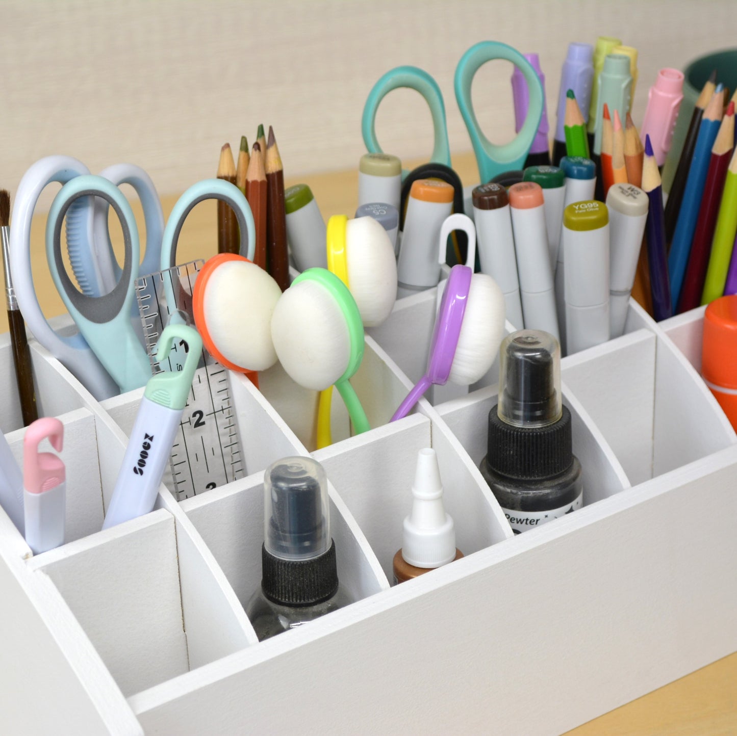 top view of craft tool caddy full of scissors, rulers, and markers