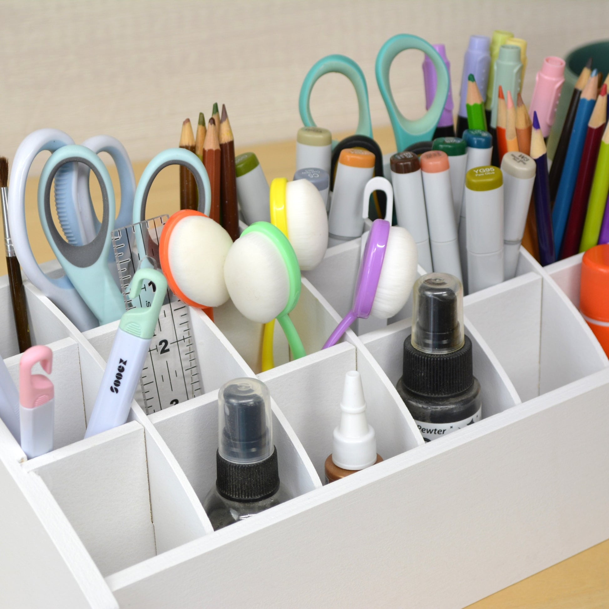 top view of craft tool caddy full of scissors, rulers, and markers