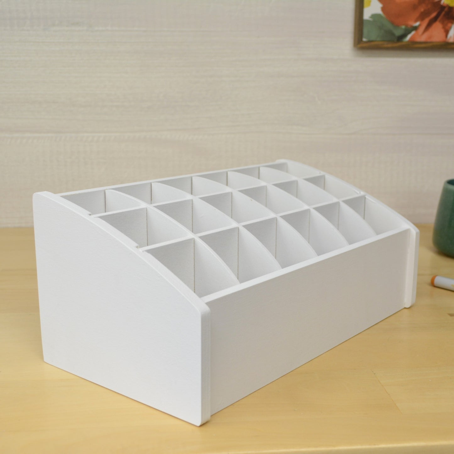 a white organizer with eighteen sections on a tabletop designed to hold craft supplies