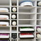 Closeup view of ink pads and refill bottles in a white handcrafted storage organizer. 