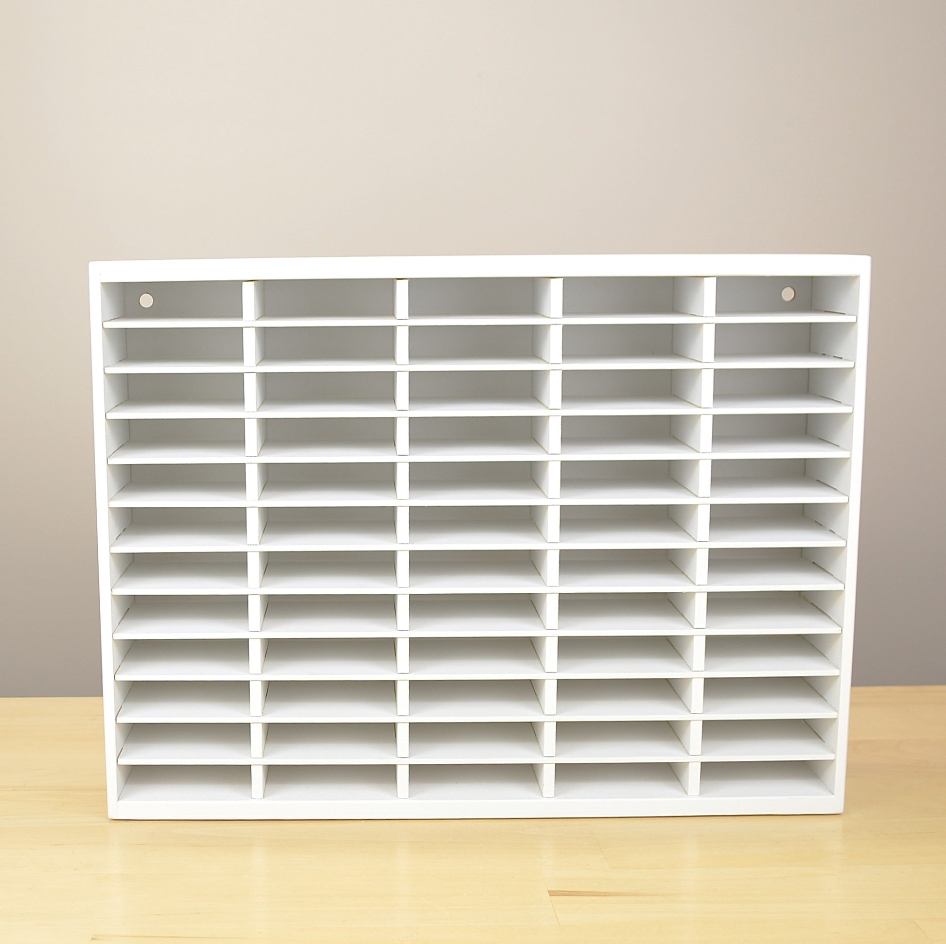 Front view of a 60 slot ink pad holder painted white. 